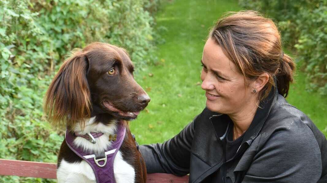 Karina Fisker på en bænk med hunde