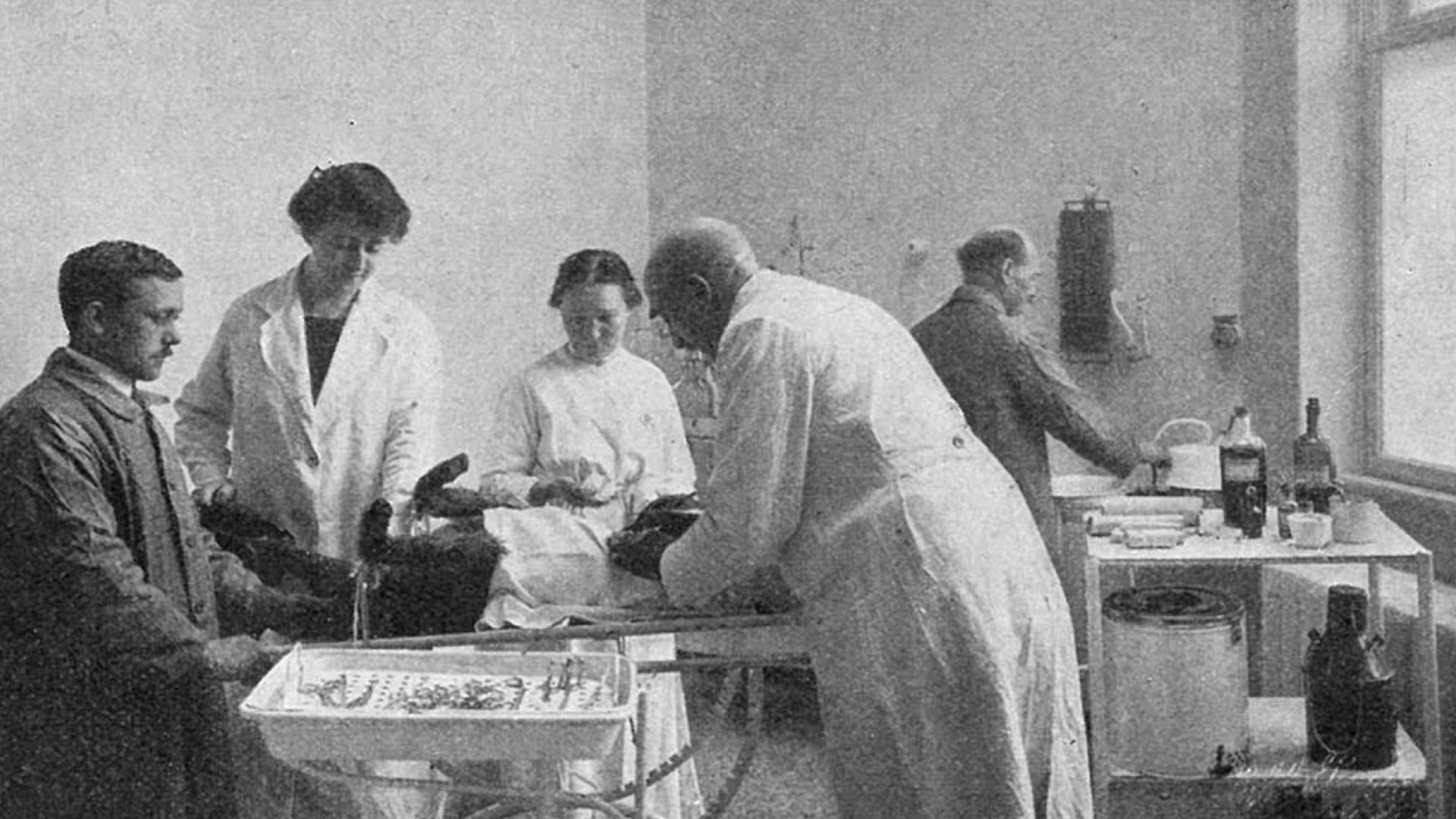 Operationsstuen på verdens første dyrehospital, der blev opført af Dyrenes Beskyttelse. Foto: Arkiv. Dyrlæge og veterinærsygeplejesker er samlet rundt om et operationsbord, hvor en hund ligger klar til operation.