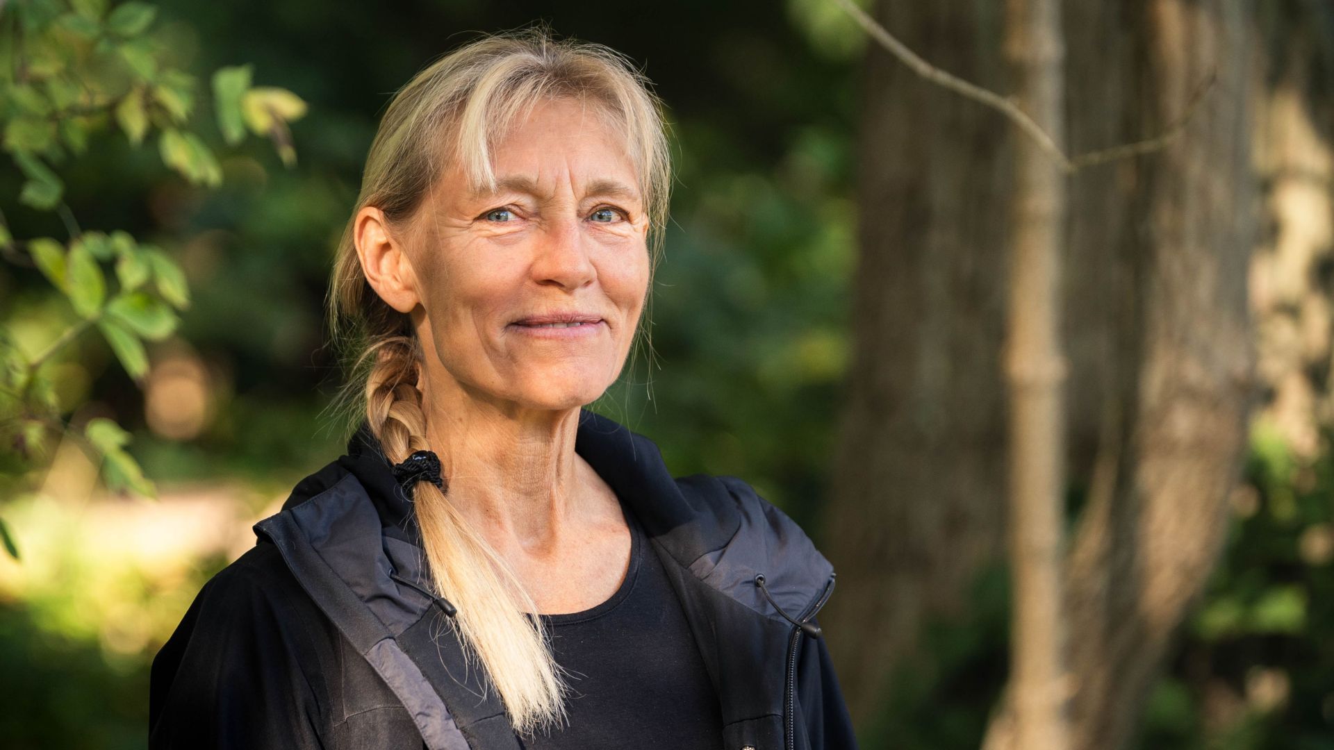 Maria Vang står i en skov og smiler til kameraet