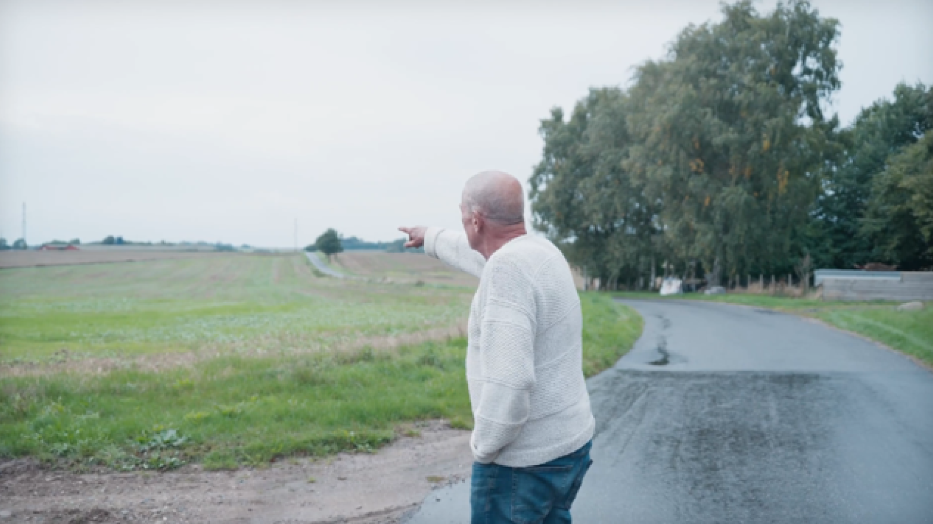 Mogens Callesen peger hen på sin nabos svinestald