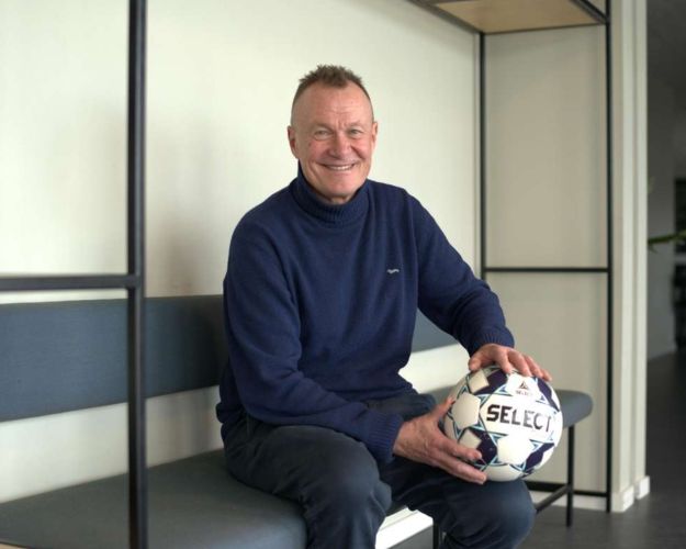 Per Frimann sidder på en bænk med en fodbold i hænderne