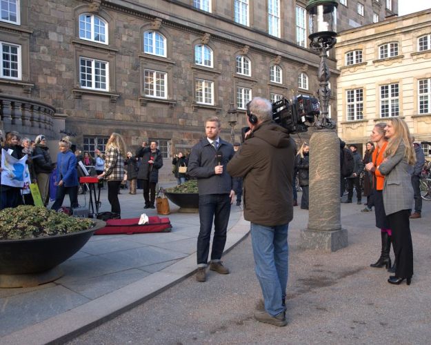 Svinestopmødet var udsolgt på halvanden time, og flere medier fandt også vej. Her er det DR, der skal til at interviewe Zenia Stampe (B) og Leila Stockmarr (Ø), mens koret God Energi synger. Foto: Cecilie Sønderstrup/Dyrenes Beskyttelse