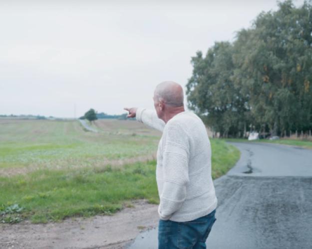 Mogens Callesen peger hen på sin nabos svinestald