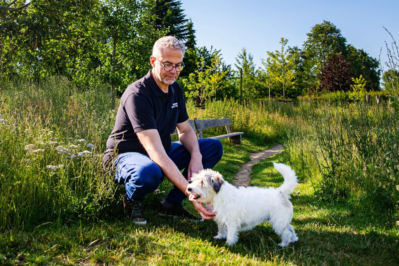 For Jens Jokumsen er et af kæledyrsejerens vigtigste opgaver at sætte sig grundigt ind i det enkelte dyrs naturlige behov og tilpasse sig efter det. Foto: Benedicte Lorenzen / Dyrenes Beskyttelse. Jens Jokumsen aer sin hund i græsset