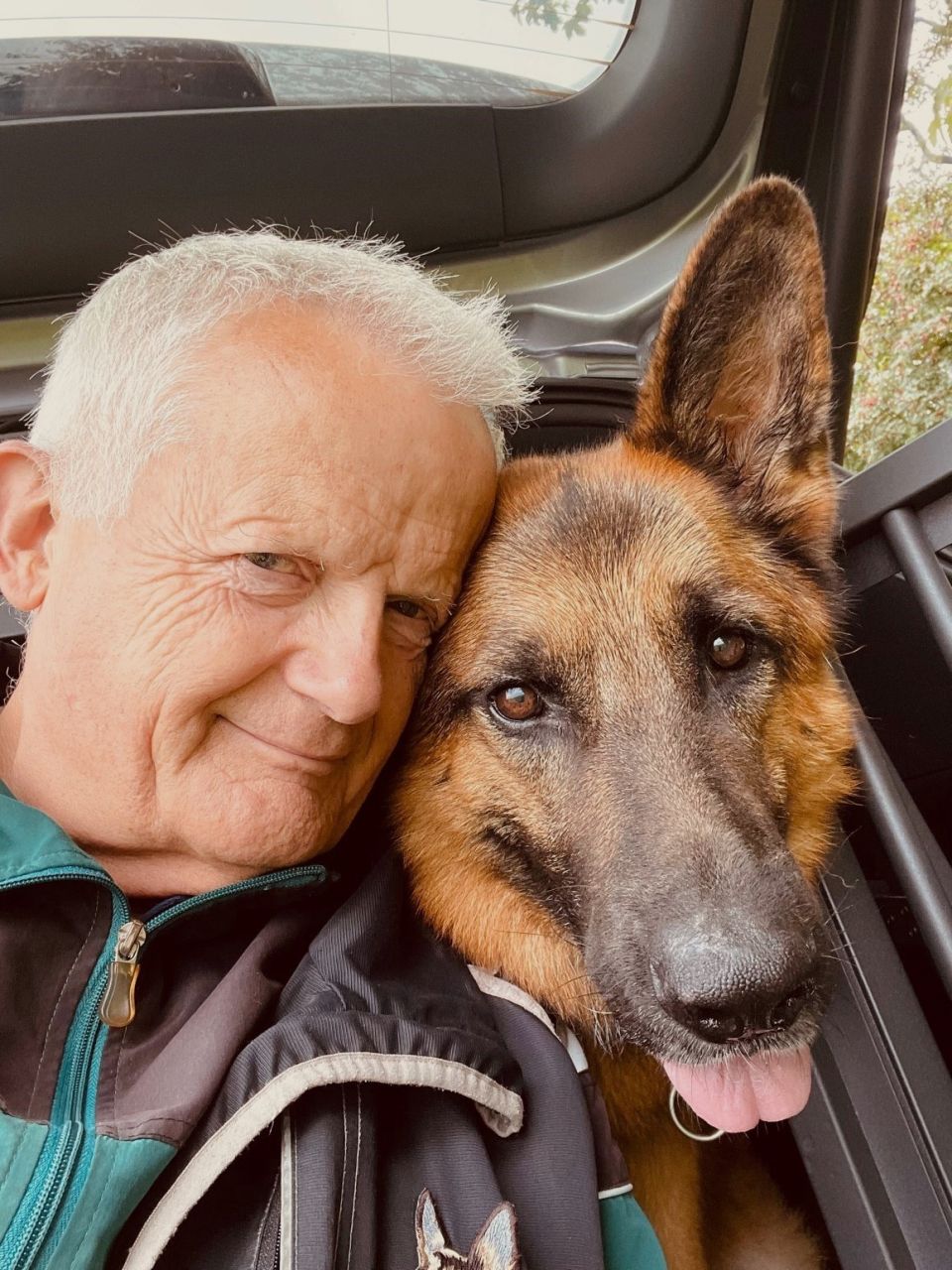 Steen Aldenborg fra Esbjerg, 70 år, arbejder som leder i jobcenter. Foto: Privat mand med gråt hår sidder sammen med schæferhund i bagsmækken på bilen